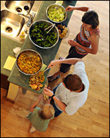 A line of people serving themselves from large serving-dishes